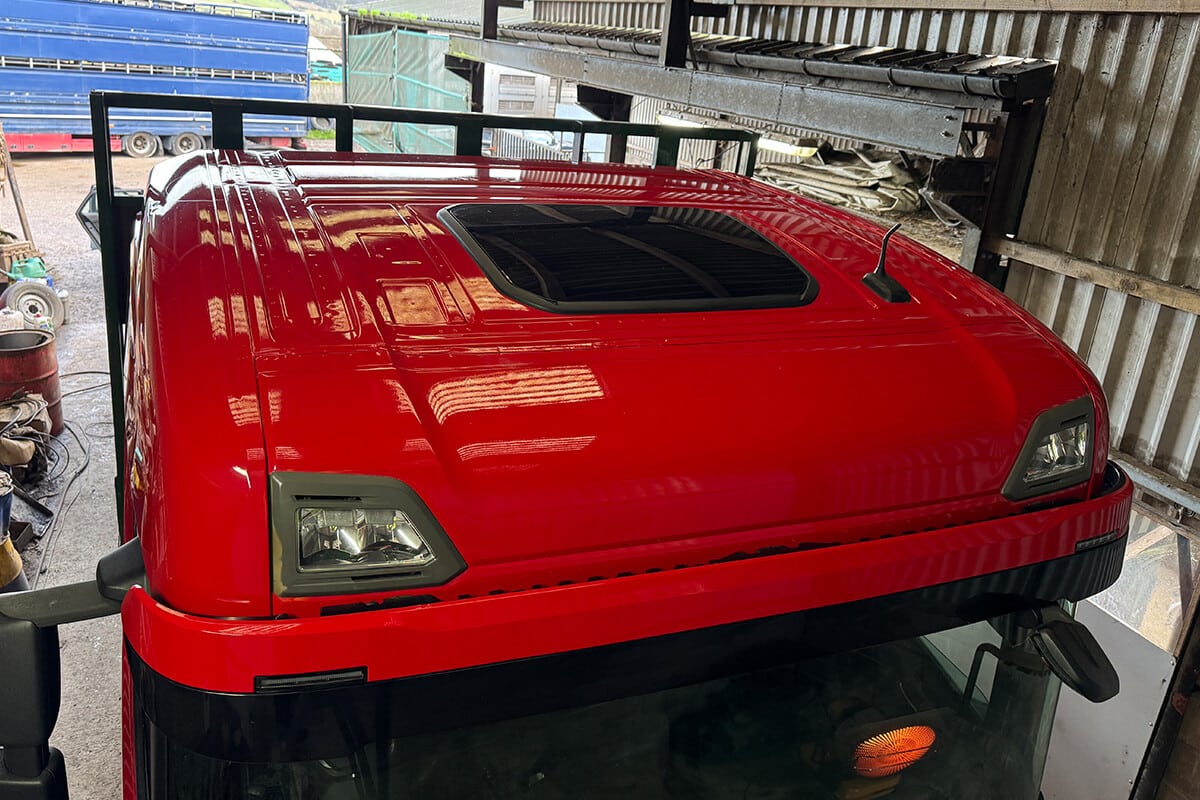 Red lorry cab receiving high-performance vinyl wrap installation