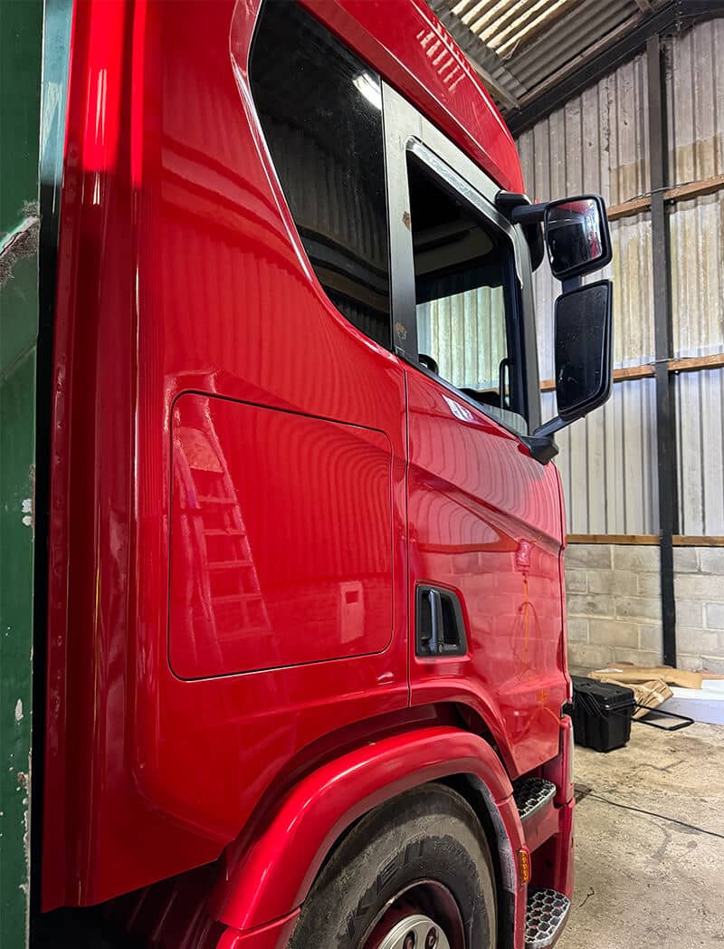 Scania front cab during vinyl alignment for commercial fleet wrap
