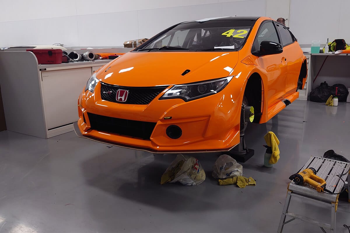 Orange Honda Civic undergoing performance wrap