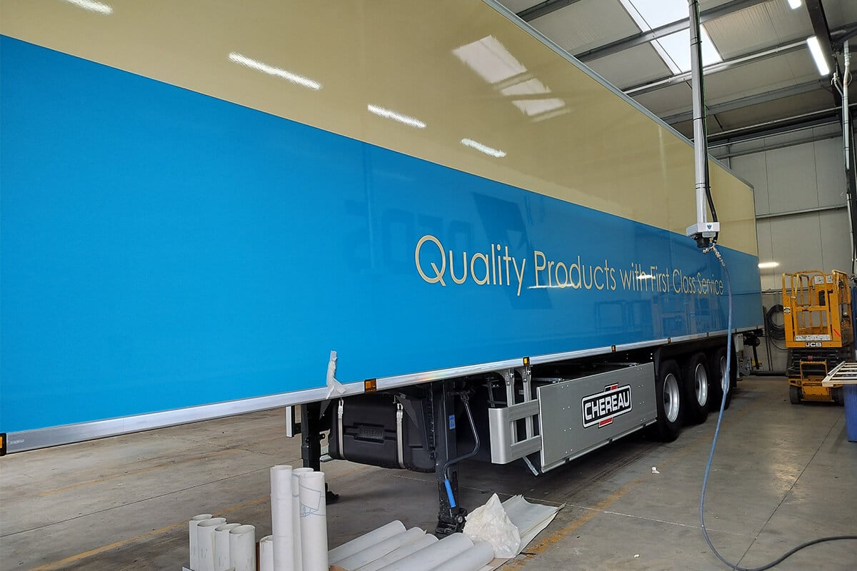 Sustainable vehicle wrap applied to blue and gold trailer graphics