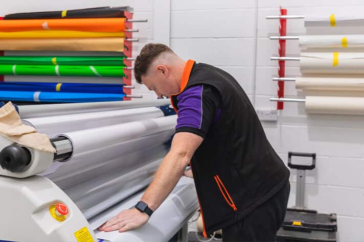 Vehicle wrap technician measuring and cutting premium wrap film at Korok Group